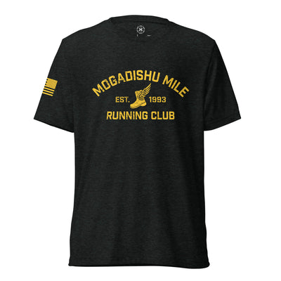 Charcoal black Mog Mile triblend Shirt, front view with yellow Mogadishu Mile Running Club lettering, winged shoe and American flag sleeve print