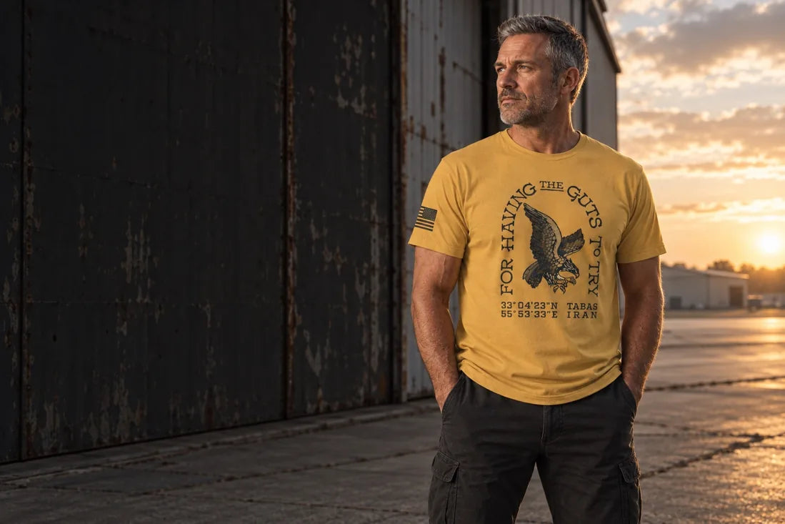 Mature man wearing the Guts to Try design at a hangar doorway — campaign illustration